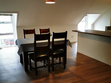 A dining room with a table and chairs in Surf-ready apartment with sea views in town