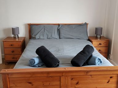 A bedroom with a bed and towels on it at Surf-ready apartment with sea views in town