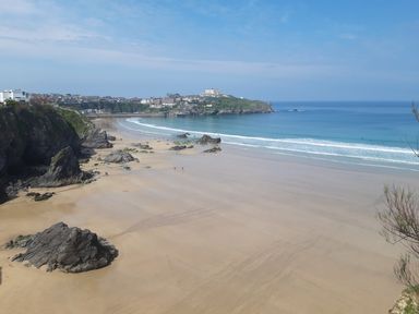 A beach with rocks and waves at Surf-ready apartment with sea views in town