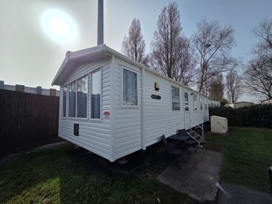 A mobile home exterior with windows and a lawn at Beach holiday base with pool and kids' activities
