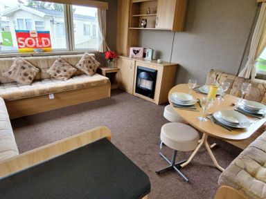 A living room with a sofa, table and fireplace at tbc in 