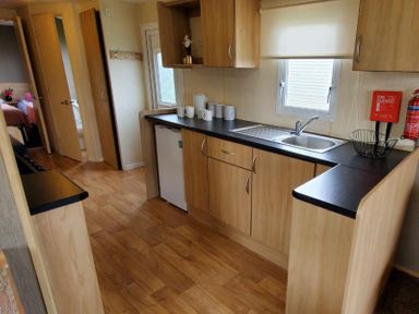 A kitchen with sink, fridge and cabinets at tbc in 