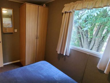A bedroom with a wardrobe and a window at tbc