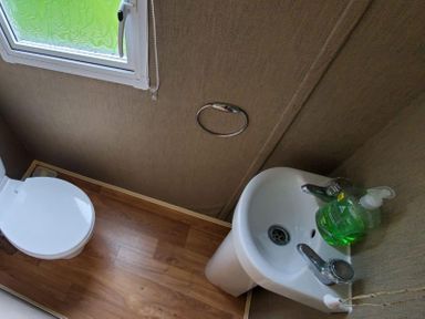 A bathroom with a toilet and a sink at tbc