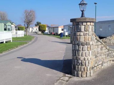 A view of a road in a caravan park with various caravans at tbc 