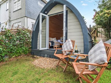 A pod with chairs and a table outside at Peaceful pod with bay views, walk to 3 beaches St Ives
