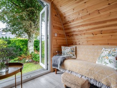A seating area with a sofa and table at Peaceful pod with bay views, walk to 3 beaches, St Ives
