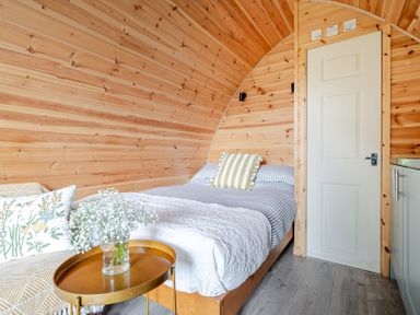 A bedroom with a bed and sofa at Peaceful pod with bay views, walk to 3 beaches, St Ives