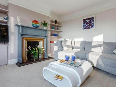 A living room with a sofa, fireplace, and coffee table at tbc in 