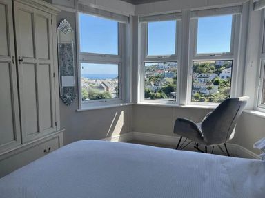 A bedroom with a wardrobe, a mirror, and a chair at tbc in 