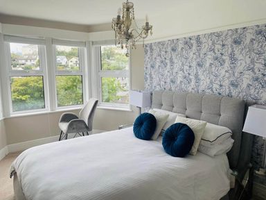 A bedroom with a bed and armchair at tbc