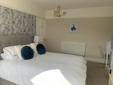 A bedroom with a bed and lamp at tbc