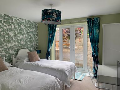 A bedroom with two single beds and a desk at tbc in 
