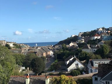 A view of houses and a sailboat by the sea at tbc in 