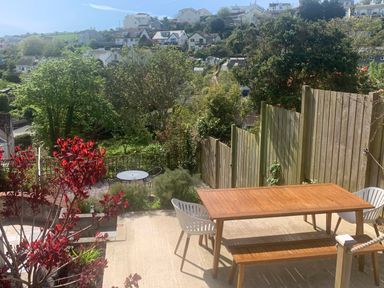 A garden with a wooden table and chairs at tbc in 
