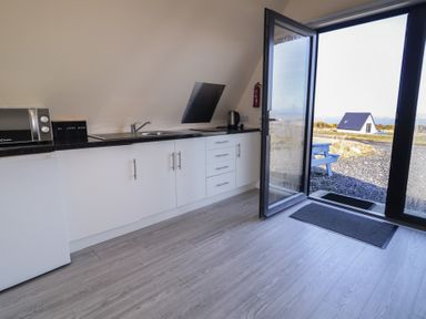 A kitchen with a sink and microwave at Cabin 9 Inish Beag in Gortahawk
