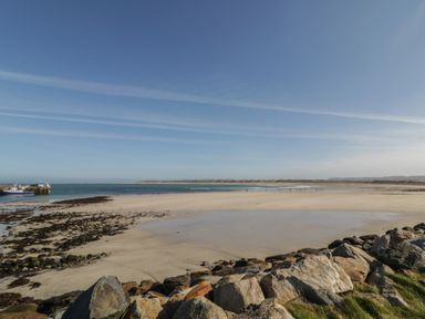 A beach with water and rocks at Cabin 9 Inish Beag in Gortahawk