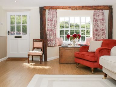 A living room with a door and window at Upper Frogpool Cottage in Crediton
