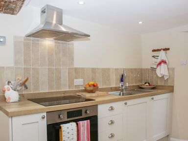 A kitchen with stovetop and sink at Upper Frogpool Cottage in Crediton