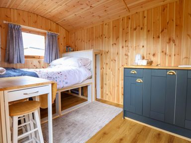 A bedroom with a bed and kitchen unit at Hazel