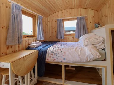 A bedroom with a bed and dining table in Hazel