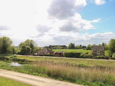 A house with trees and a pond by the road at Hazel in 