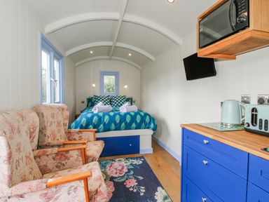 A bedroom with a bed and seating area at Skye in Clee Hill
