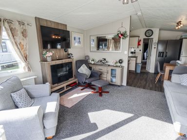 A living room with a television and sofa at 13 The Lakes in Mablethorpe