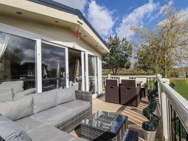 An outdoor seating area with sofa, table and chairs at 13 The Lakes in Mablethorpe