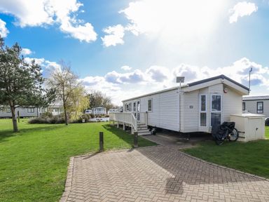 A mobile home with a deck and garden at 13 The Lakes in Mablethorpe