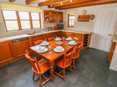A kitchen with a wooden dining table and chairs at Park Hall Cottage in Solva