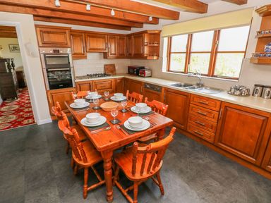 A kitchen with a wooden table and chairs at Park Hall Cottage in Solva