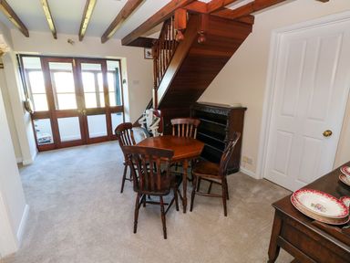 A dining room with a table and chairs at Park Hall Cottage Solva