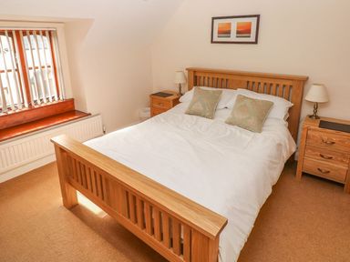 A bedroom with a wooden bed and bedside tables at Maerdy Lodge