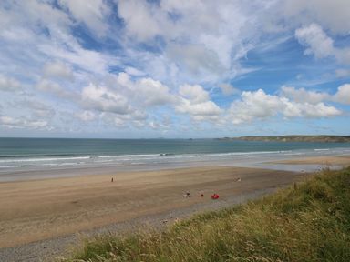 A beach with ocean waves and clouds at Maerdy Lodge