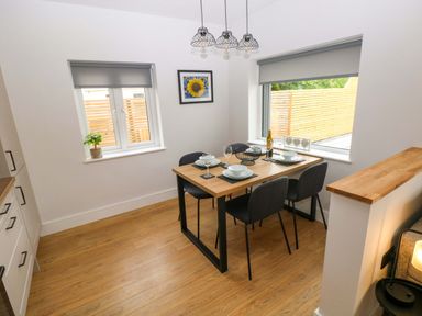 A dining room with a table and chairs at Y Bwthyn Burry Port