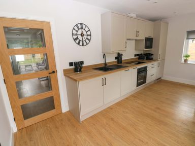 A kitchen with a sink and appliances at Y Bwthyn in Burry Port