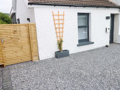 An outdoor area with a fence and planter at Y Bwthyn Burry Port