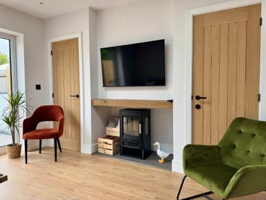 A living room with a television and chairs at Y Bwthyn in Pembrey