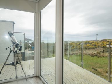 A conservatory with a telescope and views of hills at 2 Ard an Chuain Dunfanaghy
