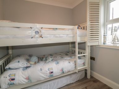 A bunk bed with blue and white bed linen and plush toys at 2 Ard an Chuain Dunfanaghy