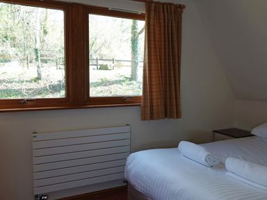 A bedroom with a bed and a window at Bracken Lodge Finlakes Holiday Park near Chudleigh