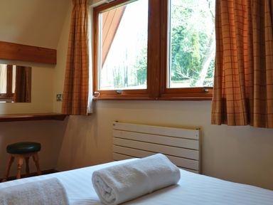 A bedroom with a window and a bed at Bracken Lodge in Finlakes Holiday Park near Chudleigh