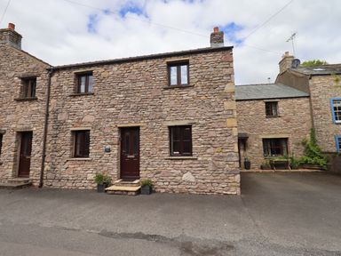 A stone house with windows and a front door at 4 Mellbecks Mews Kirkby Stephen
