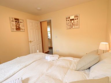 A bedroom with a bed and door at 4 Mellbecks Mews Kirkby Stephen
