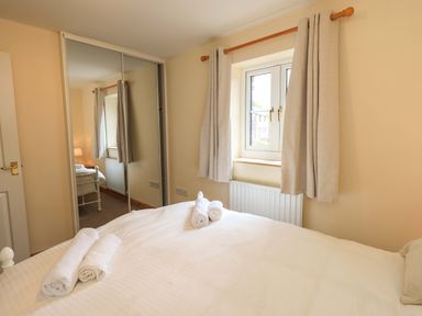 A bedroom with a bed and towels on top at 4 Mellbecks Mews in Kirkby Stephen