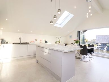 A kitchen with an island and dining area at Meadow Retreat in Bodmin