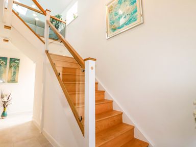 A staircase with wooden steps and decorative elements at Meadow Retreat in Bodmin
