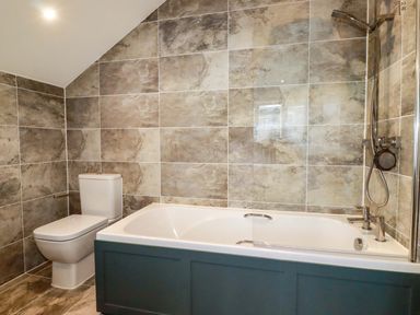 A bathroom with a bathtub and toilet at Meadow Retreat in Bodmin