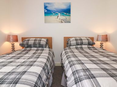 A bedroom with twin beds and lamps at Meadow Retreat in Wadebridge